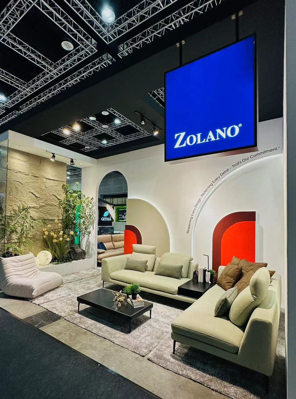 A stylish Zolano furniture display at HOMEDEC Kuala Lumpur 2023 showcasing modern sofas and decor.