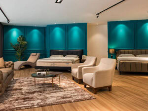 Elegant modern bedroom showroom with stylish furniture and vibrant teal wall panels.