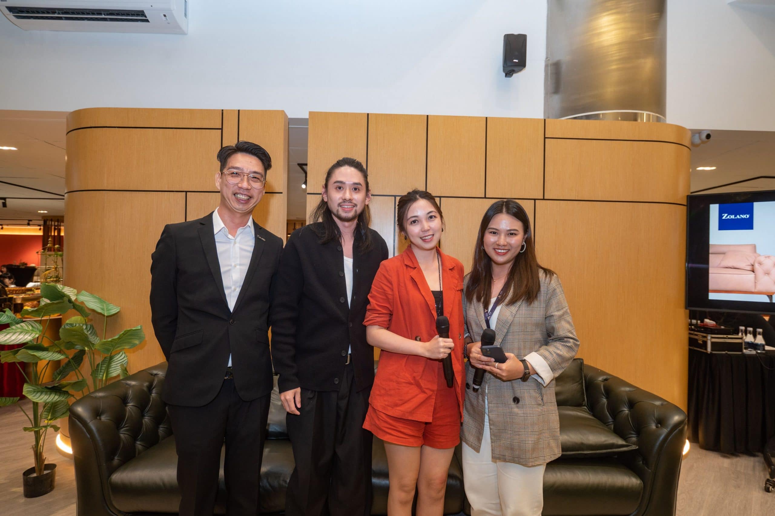 Elegant group of four people at Zolano furniture event, showcasing modern interior design.