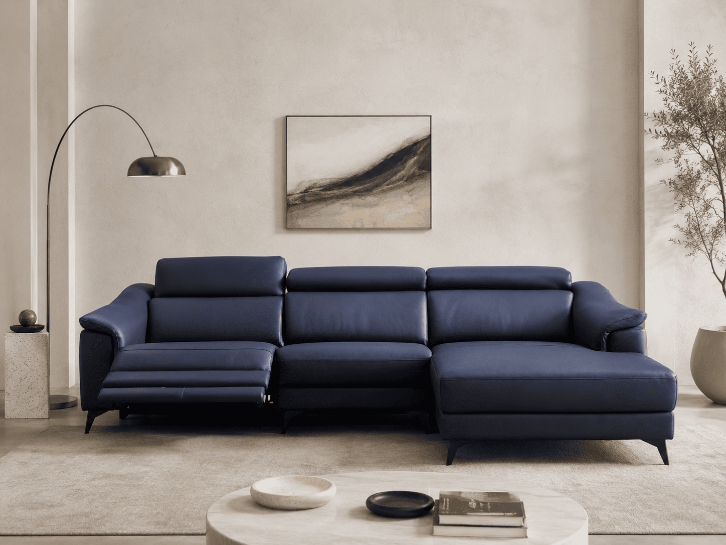 Modern navy blue sectional sofa in a minimalist living room with artwork and plants.