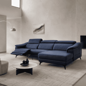 Modern navy blue sectional sofa in a minimalist living room with fireplace and artwork.