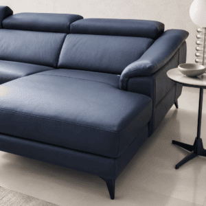 Modern blue leather sofa with black legs in a minimalist living room setting.