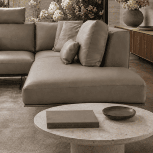 Modern grey leather sofa with cushions in a stylish living room with floral decor.