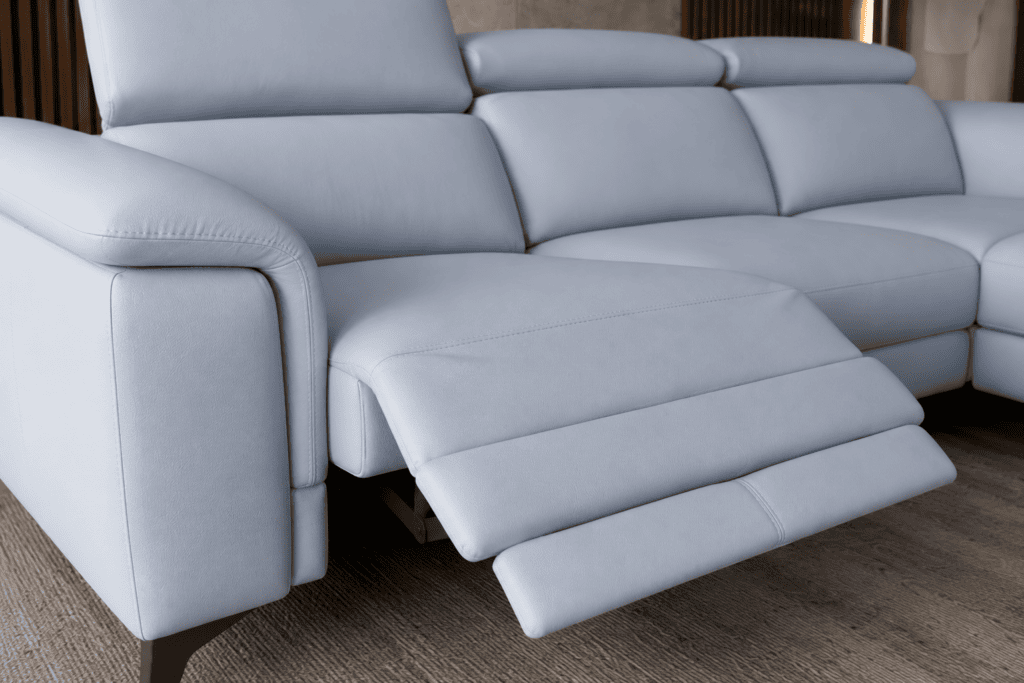 Modern light grey sectional sofa with adjustable footrest in living room.