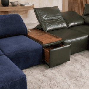 Modern living room with navy and green sofas and wooden side table.