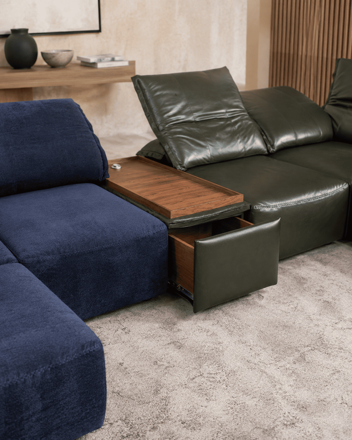 Modern living room with navy and green sofas and wooden side table.
