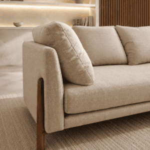 Modern beige sofa with wooden legs in a stylish living room setting.
