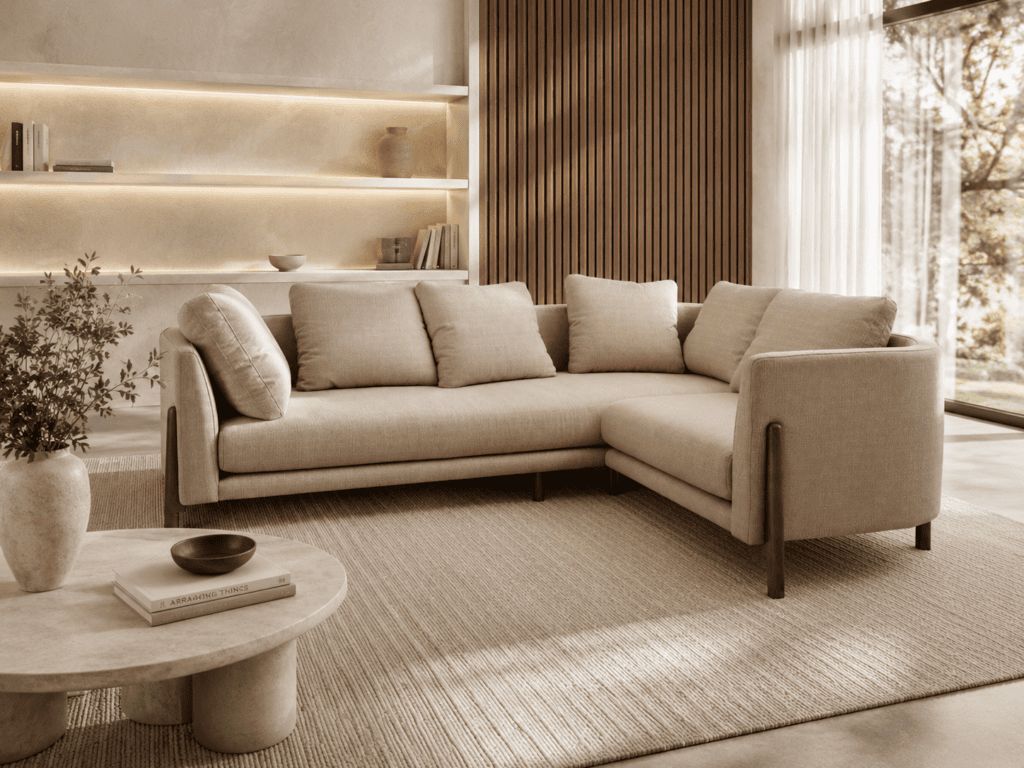 Modern beige L-shaped sofa in a stylish living room with natural light.