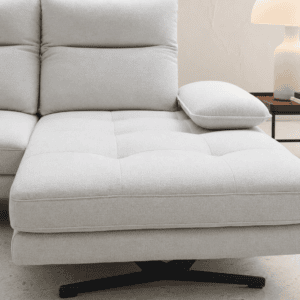 Modern light grey sofa with cushion and side table with lamp in living room.