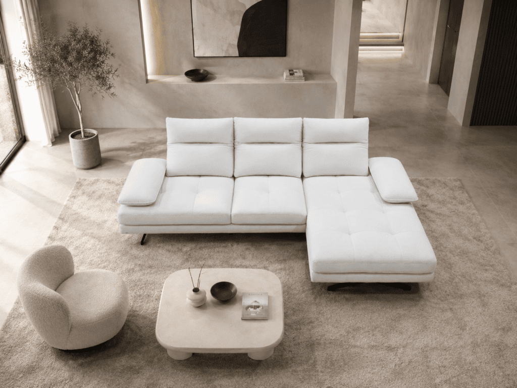 Modern white sectional sofa with chaise lounge in stylish living room.