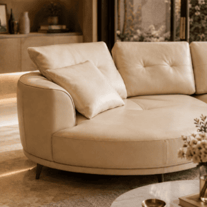 Elegant cream sofa with cushions in a modern living room with large windows and natural light.