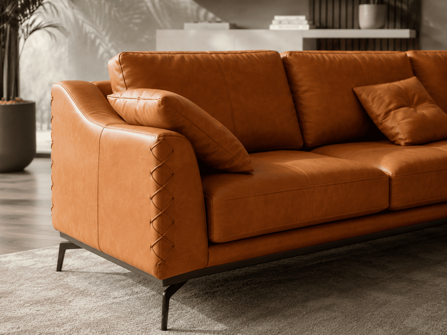 Elegant brown leather sofa with matching cushions in modern living room setting.